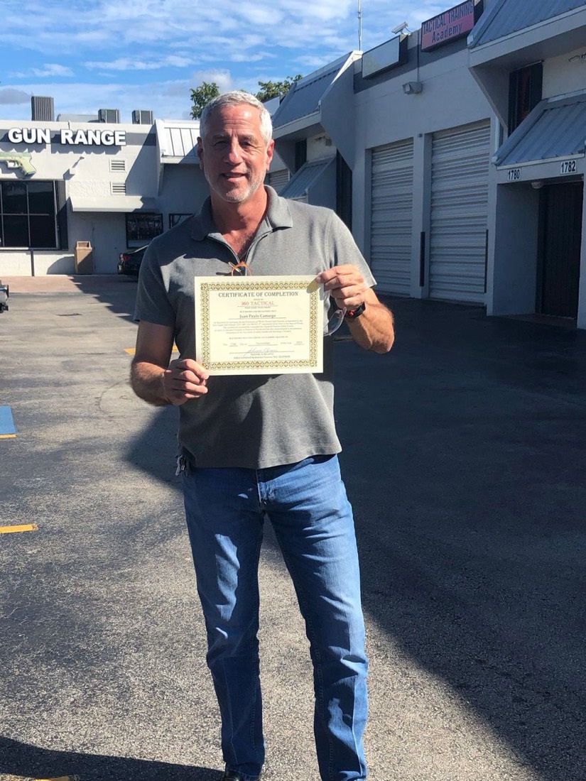 Student holding CCW certificate of completion outside the gun range in Miami