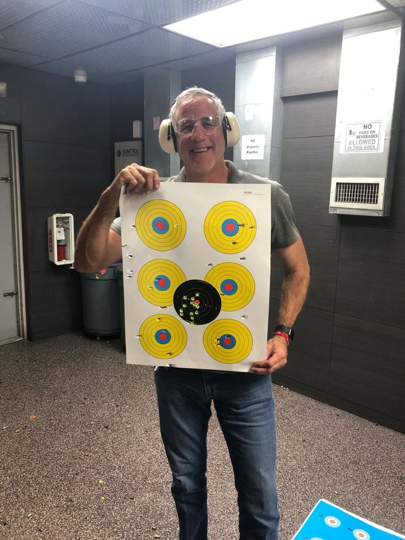 Student proudly displaying target after firearms training in Miami